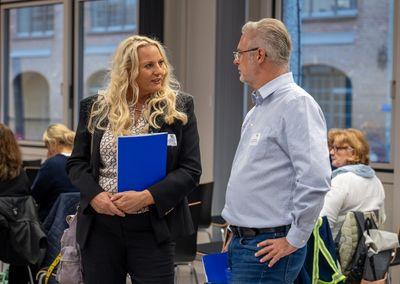 Abschlussveranstaltung #ABCforJobs "Quo Vadis" - (c)2bScene Eine Frau mit langen blonden Haaren spricht mit einem Mann in einem hellen Raum.