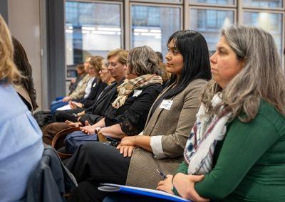 Zwei Personen unterhalten sich bei einer Kaffeepause, beide halten Tassen in der Hand.