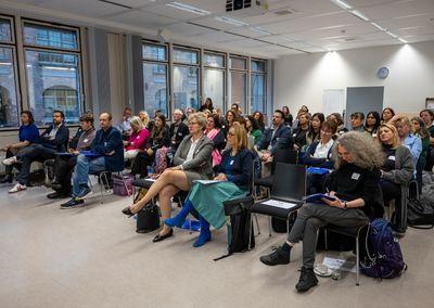Zwei Frauen beugen sich über einen Tisch und füllen gemeinsam Unterlagen aus.