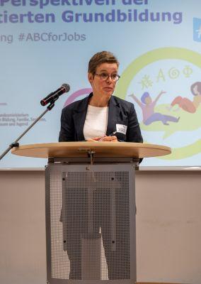 Zwei Personen unterhalten sich bei einer Kaffeepause, beide halten Tassen in der Hand.