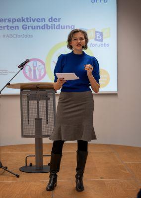 Drei Personen stehen im Gespräch in einem Veranstaltungsraum.