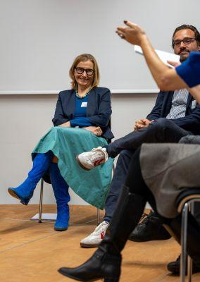 Zwei Frauen beugen sich über einen Tisch und füllen gemeinsam Unterlagen aus.