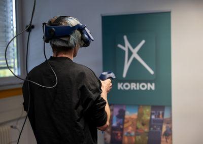 Eine Person trägt eine VR-Brille und hält Controller in den Händen, um eine virtuelle Lernanwendung zu testen.