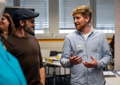 Zwei Personen stehen in einem Raum und unterhalten sich lebhaft bei der Abschlussveranstaltung #ABCforJobs.