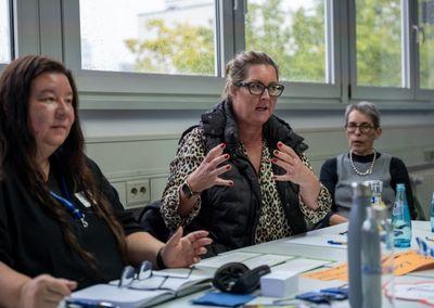 Eine Person hält ein Tablet und testet eine digitale Lernanwendung mit einem Sonnensymbol auf dem Bildschirm.