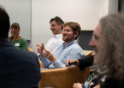 Zwei Personen betrachten eine Wand mit Fotos, Texten und QR-Codes aus dem Projekt #ABCforJobs.