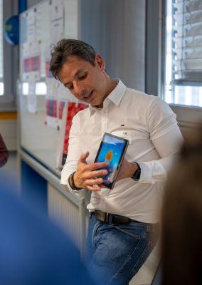Zwei Personen unterhalten sich bei einer Kaffeepause, beide halten Tassen in der Hand.