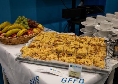 Drei Personen stehen im Gespräch in einem Veranstaltungsraum.