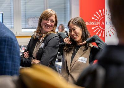 Eine Person hält ein Tablet und testet eine digitale Lernanwendung mit einem Sonnensymbol auf dem Bildschirm.