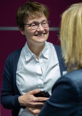 Zwei Personen betrachten eine Wand mit Fotos, Texten und QR-Codes aus dem Projekt #ABCforJobs.