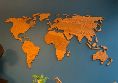 Große Weltkarte aus Holz an einer dunkelblauen Wand im World Café.